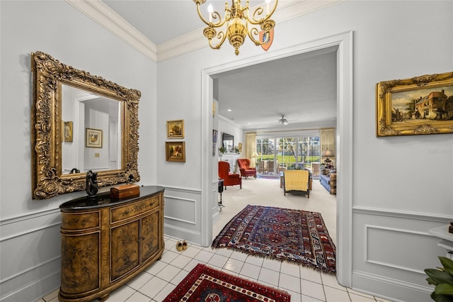 corridor with a notable chandelier, light tile patterned floors, and crown molding