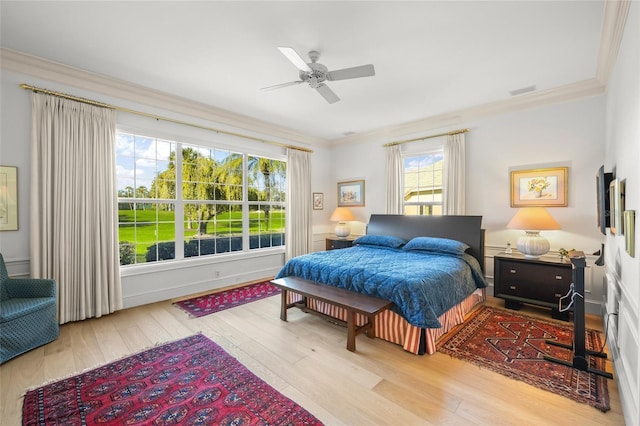 bedroom with ceiling fan, light hardwood / wood-style flooring, and ornamental molding