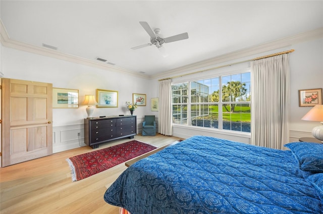 bedroom with hardwood / wood-style floors, ceiling fan, and crown molding