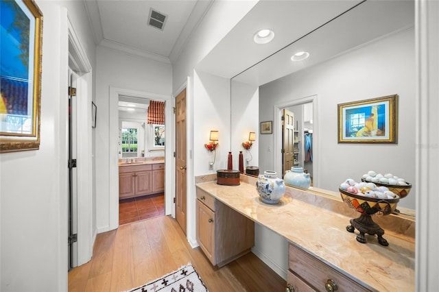 bathroom with hardwood / wood-style floors, ornamental molding, and vanity