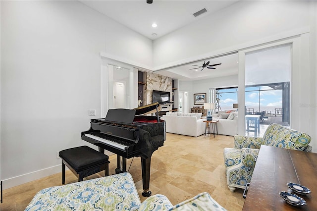 misc room featuring a premium fireplace and ceiling fan