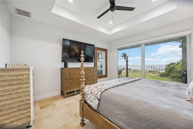 bedroom featuring a raised ceiling, ceiling fan, and access to outside