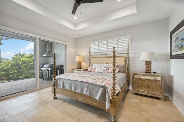 bedroom featuring a raised ceiling, multiple windows, ceiling fan, and access to outside