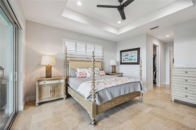 bedroom with a raised ceiling, a closet, ceiling fan, and a spacious closet