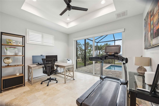 office featuring ceiling fan and a tray ceiling