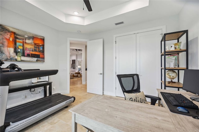 office with light tile patterned floors, ceiling fan, and a tray ceiling