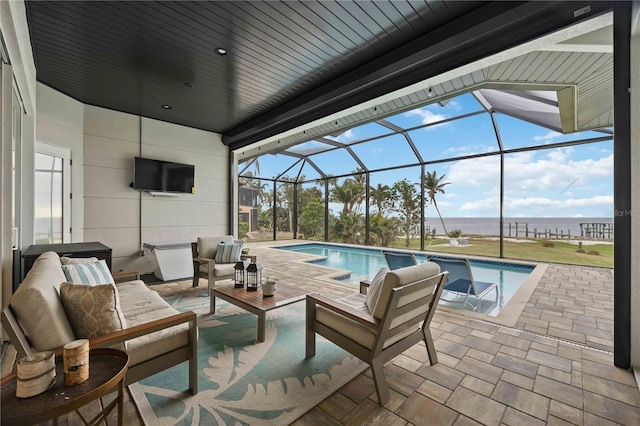 view of pool featuring a patio area, an outdoor hangout area, and glass enclosure