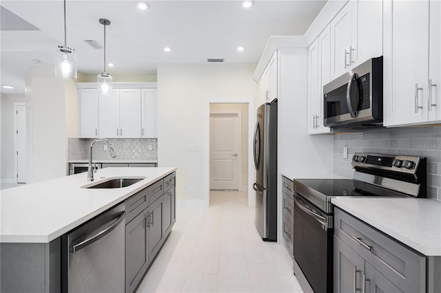 kitchen featuring sink, white cabinets, decorative light fixtures, gray cabinets, and appliances with stainless steel finishes