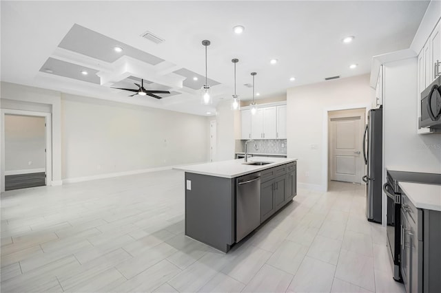 kitchen with stainless steel appliances, sink, white cabinetry, an island with sink, and coffered ceiling