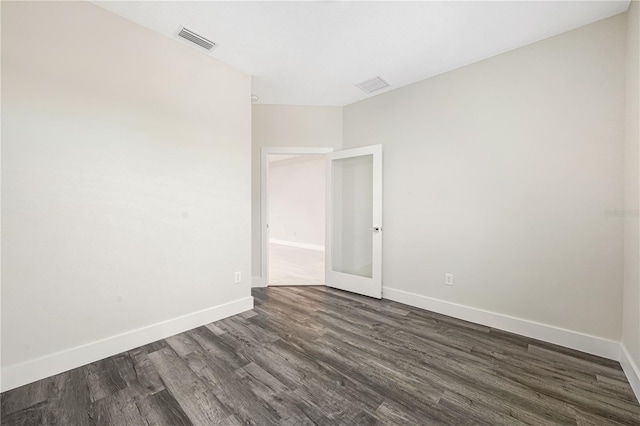 spare room featuring dark wood-type flooring and french doors