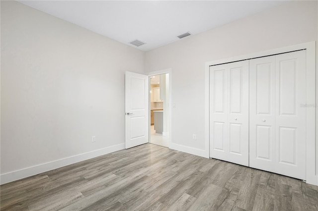 unfurnished bedroom featuring a closet and light hardwood / wood-style floors