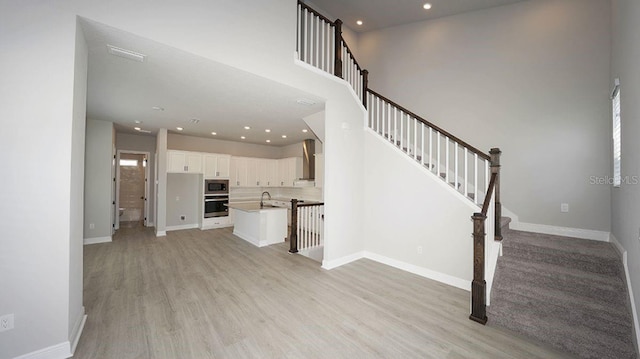 unfurnished living room with light hardwood / wood-style floors and sink