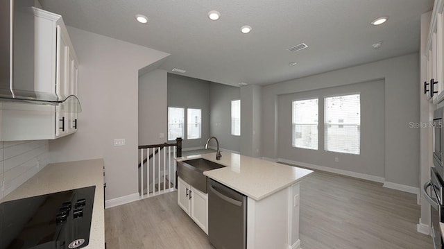 kitchen featuring sink, white cabinetry, stainless steel dishwasher, and a center island with sink