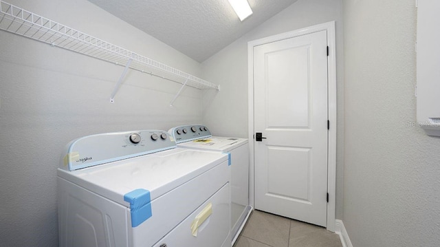 laundry room featuring light tile patterned floors, a textured ceiling, and separate washer and dryer