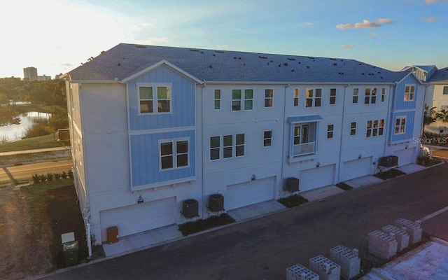 exterior space with a garage and central AC