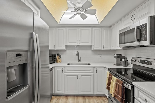 kitchen featuring sink, stainless steel appliances, and white cabinetry