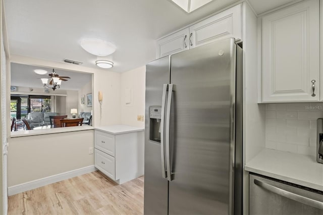 kitchen with white cabinets, ceiling fan, light hardwood / wood-style floors, decorative backsplash, and appliances with stainless steel finishes