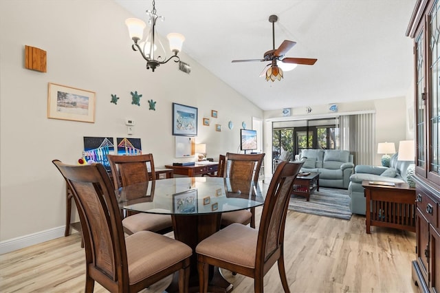 dining area featuring light wood-type flooring, lofted ceiling, and ceiling fan with notable chandelier