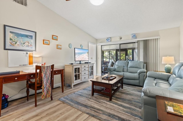 living room with vaulted ceiling and light hardwood / wood-style flooring