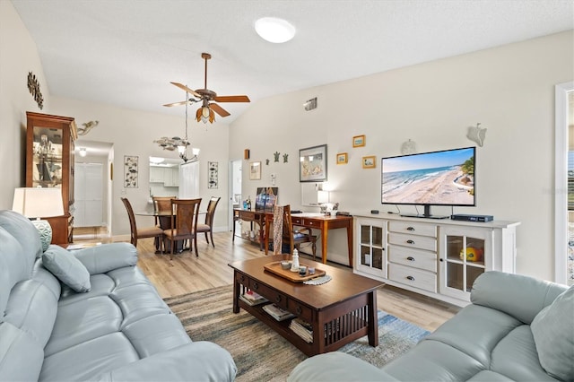 living room with vaulted ceiling, light wood-type flooring, ceiling fan, and a textured ceiling