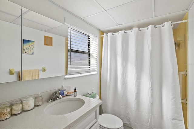 bathroom featuring a paneled ceiling, vanity, and toilet