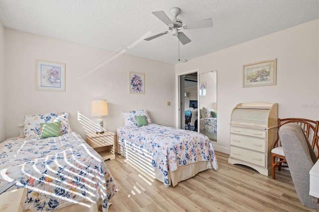 bedroom featuring a closet, a textured ceiling, ceiling fan, and light hardwood / wood-style flooring