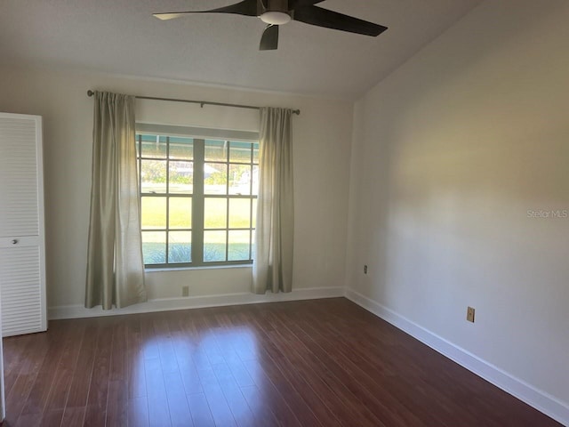 empty room with dark wood-type flooring and ceiling fan