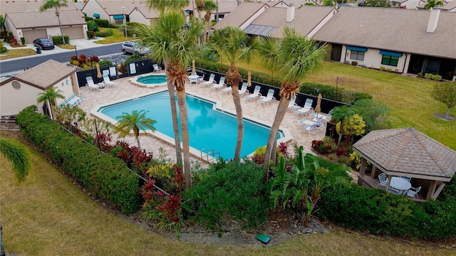 view of pool featuring a gazebo, a community hot tub, a patio, and a lawn