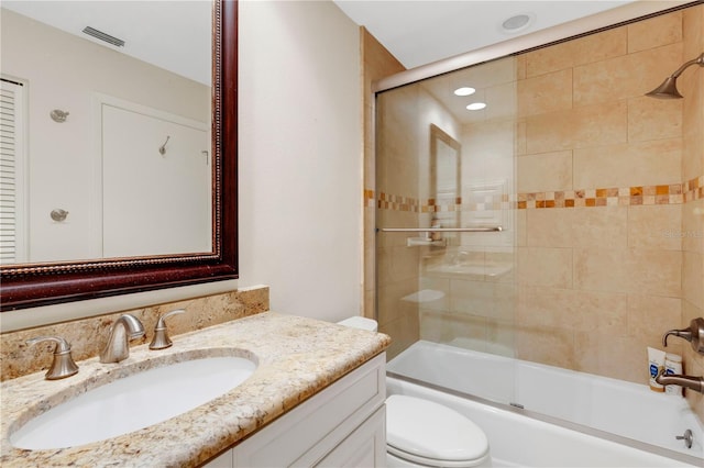 full bathroom with vanity, shower / bath combination with glass door, and toilet