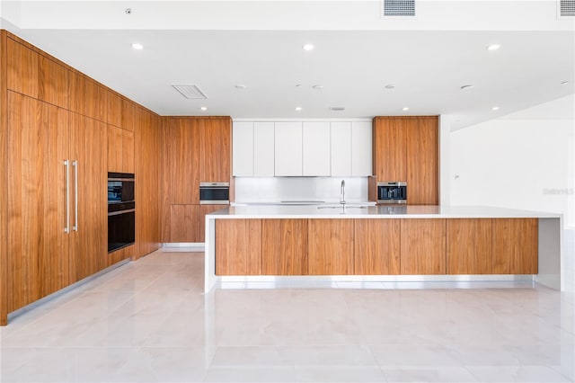 111 Golden Gate Pt Unit 701Ph, Sarasota, FL 34236 - kitchen featuring light countertops, a sink, modern cabinets, and visible vents