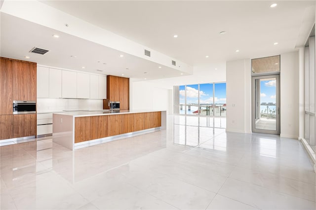 111 Golden Gate Pt Unit 701Ph, Sarasota, FL 34236 - kitchen featuring modern cabinets, visible vents, a spacious island, and oven