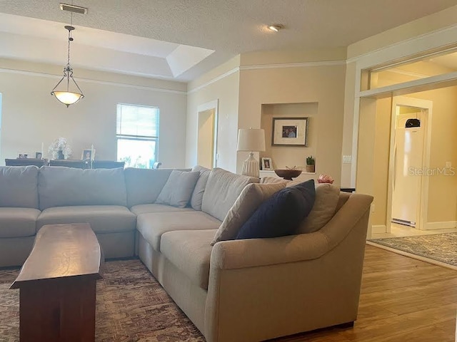 living room featuring a textured ceiling, crown molding, and dark wood-type flooring