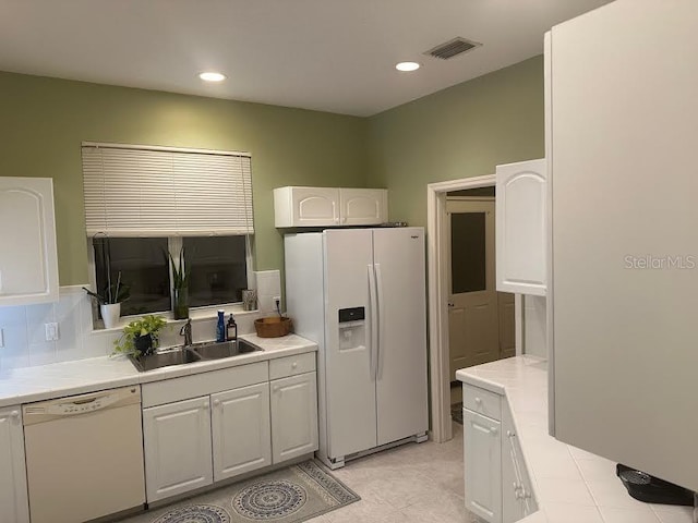 kitchen featuring white cabinetry, sink, backsplash, white appliances, and light tile patterned floors