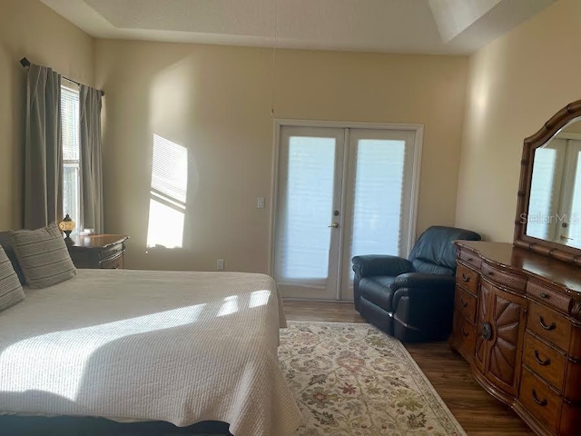 bedroom with access to exterior, french doors, and dark wood-type flooring