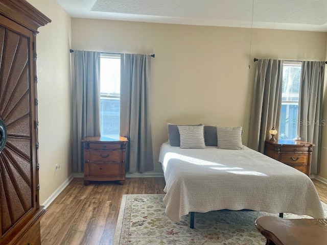 bedroom featuring wood-type flooring and multiple windows