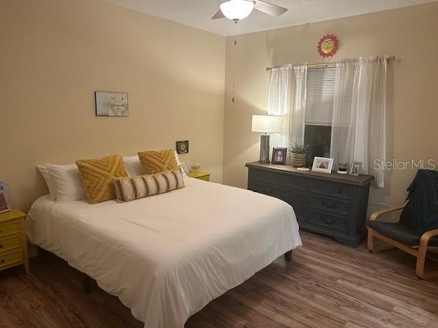 bedroom with ceiling fan and dark wood-type flooring