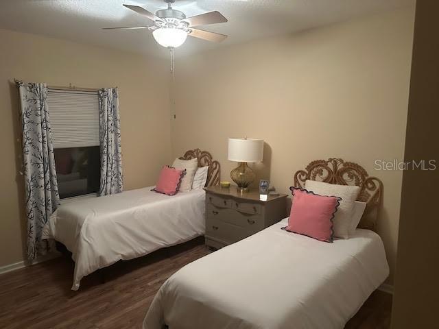 bedroom with dark hardwood / wood-style floors and ceiling fan