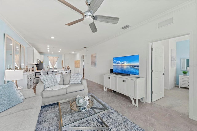 carpeted living room featuring ceiling fan and crown molding