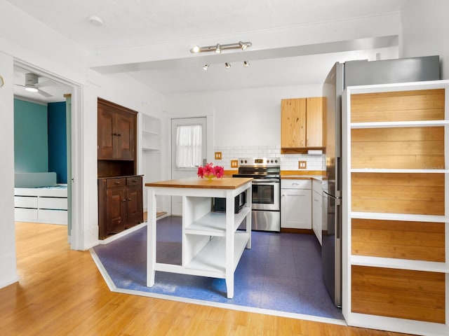 kitchen featuring decorative backsplash, light wood-type flooring, stainless steel appliances, ceiling fan, and white cabinetry