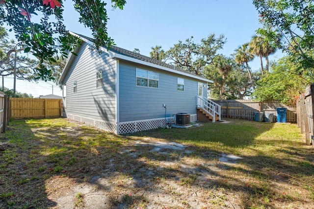 rear view of house with a yard and central air condition unit