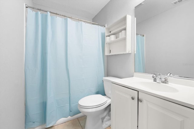 bathroom featuring tile patterned flooring, vanity, and toilet