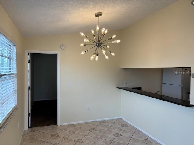 unfurnished dining area with vaulted ceiling, a textured ceiling, and an inviting chandelier