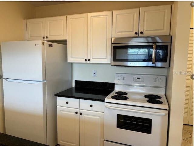 kitchen featuring light tile patterned floors, white appliances, and white cabinetry