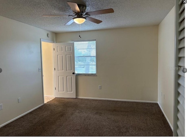 carpeted empty room with ceiling fan and a textured ceiling