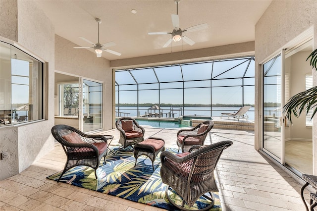 sunroom featuring a water view and ceiling fan