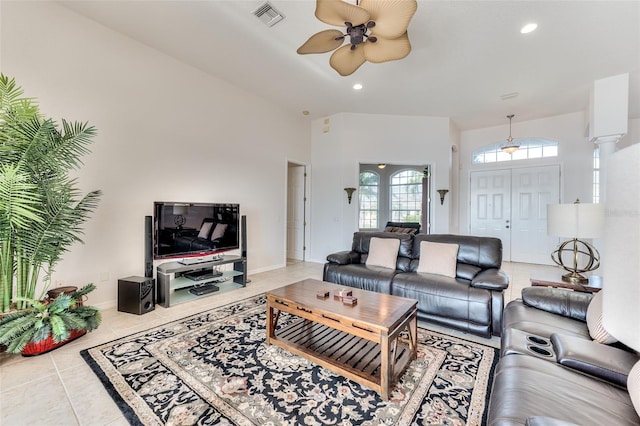 living room with ceiling fan, tile patterned floors, a high ceiling, and decorative columns