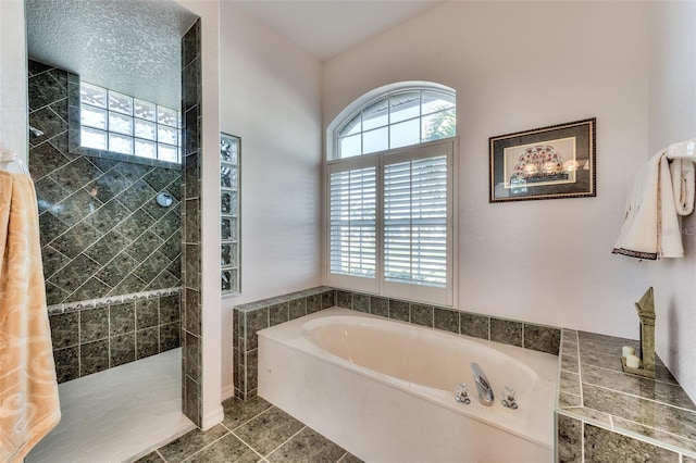 bathroom featuring tile patterned flooring and shower with separate bathtub