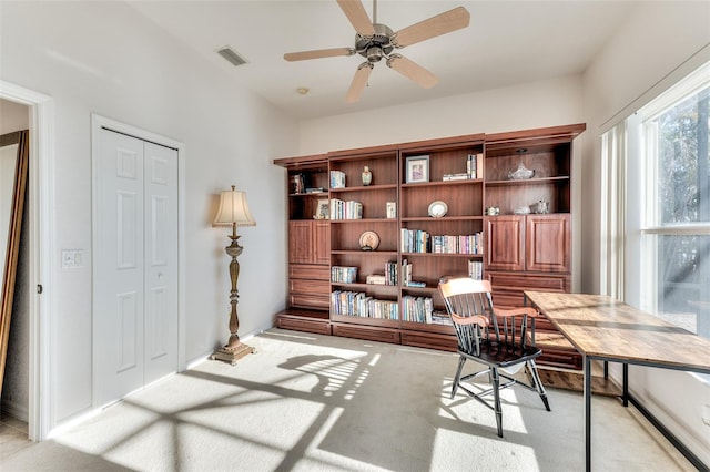 office space with light carpet and ceiling fan