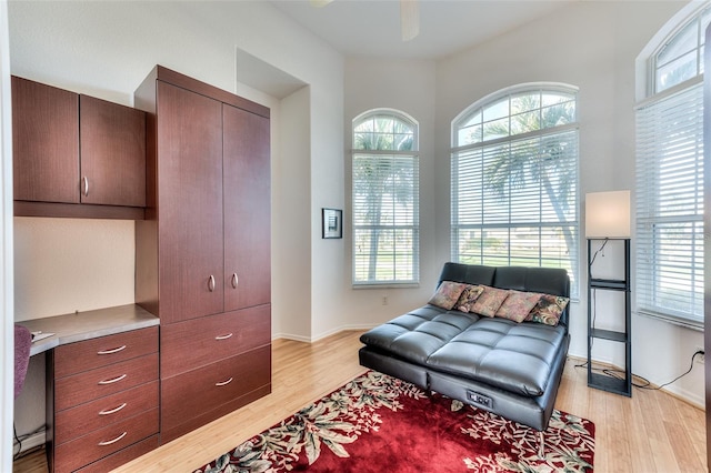 living area featuring light wood-type flooring and ceiling fan