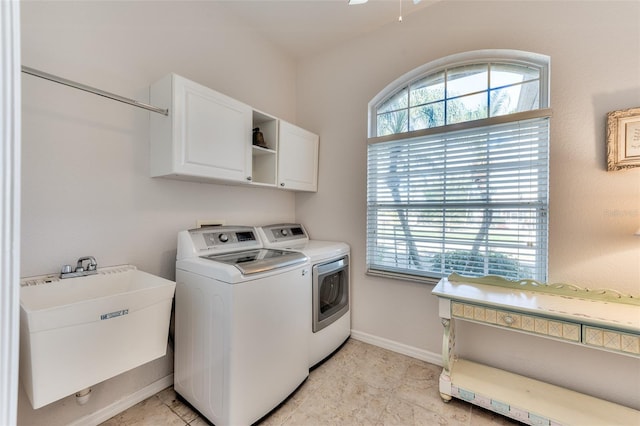 washroom with cabinets, washer and clothes dryer, and sink